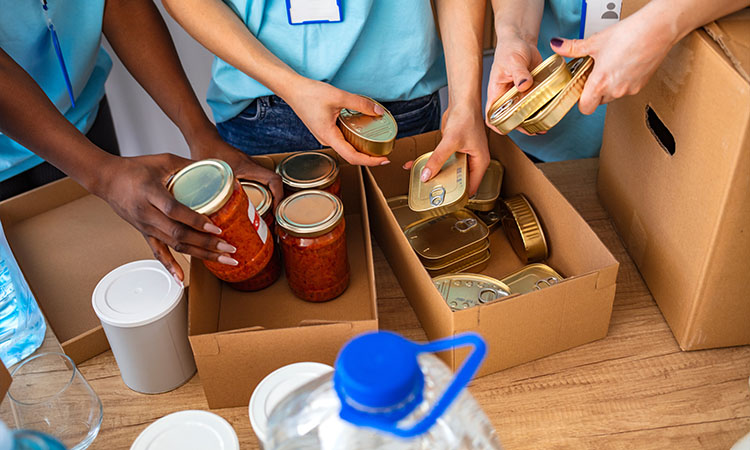 People with canned goods in boxes